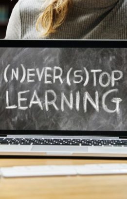 A computer screen in from of a woman that says, "Never stop learning"