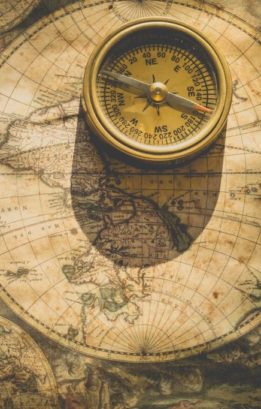 A compass on a World Map. To reach a destination requires direction.