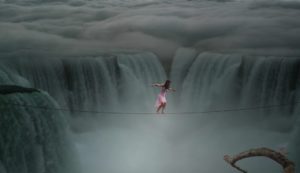 Lady on a high wire over a waterfall.